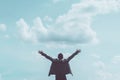 Copy space of man rising hands on blue sky white clouds abstract background. Freedom feel good and travel adventure concept