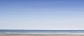 Copy space at the sea with a clear blue sky background above the horizon. Panoramic of calm ocean waters across a beach Royalty Free Stock Photo