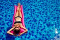 Copy space spf and sunscreen beautiful brunette girl floating in the pool water.woman swimming and relaxing on pink Royalty Free Stock Photo