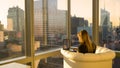 COPY SPACE: Woman working on her computer from her home office facing the city. Royalty Free Stock Photo