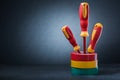 Copy space view three insulated electrical screwdrivers standing in stack of rolls insulation tapes on black background Royalty Free Stock Photo