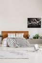 Copy space on white wall with black map in modern bedroom with king size bed with wooden headboard Royalty Free Stock Photo