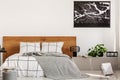 Copy space on white wall with black map in modern bedroom with king size bed with wooden headboard