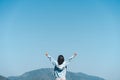 Copy space of woman raise hand up on top of mountain and blue sky cloud abstract background. Freedom feel good and travel