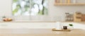 A copy space on a wooden tabletop with a coffee pot and a coffee cup in a minimal bright kitchen