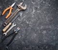 Copy space of working tools on a black concrete surface. Nippers, wrench keys, pliers, screwdriver. Top view