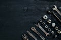 Copy space of working tools on a black wooden surface. Nippers, wrench keys, pliers, screwdriver. Top view.