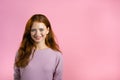 Copy space. Young smiling woman with red hairstyle looking to camera. Portrait of cute beautiful girl on pink studio Royalty Free Stock Photo