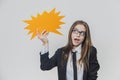 Adorable business woman is holding a orange speech bubble, which is star-shaped, isolated, on the white background