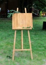 Wooden easel with a board. On the board written white paint - Welcome. Royalty Free Stock Photo