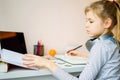 Teenage girl studying something using computer and headphones at home Royalty Free Stock Photo