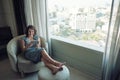 Happy laughs woman siting on the chair near the window and using Digital Tablet