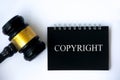 Copyright law text on black notepad and gavel on white background cover. Royalty Free Stock Photo