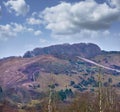 Copyspace and landscape of the mountain slope with grass and narrow passages below cloudy sky. Inclining side view of a