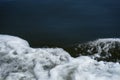 Copyspace scene of deep blue sea light circular ripple background with moving white bubble foam water waving by running boat