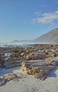 Copyspace at sea with a blue sky background and rocky coast in Camps Bay, Cape Town in South Africa. Boulders at a beach Royalty Free Stock Photo