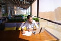 Copywriter typing text on laptop at cafe table.