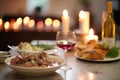 coq au vin on a dining table, candles, and wine in background