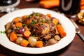 coq au vin with pearl onions and carrots on a plate
