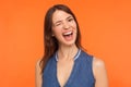 Coquettish happy brunette woman in denim outfit winking playfully at camera and smiling Royalty Free Stock Photo