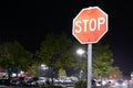 Motion of stop sign in front of parking lot at raining night Royalty Free Stock Photo