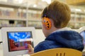 Coquitlam, Canada - December 17, 2018: Elementary school boy in library, using touchscreen computer for education