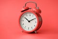 Coral old alarm clock on red background