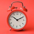 Coral old alarm clock on red background