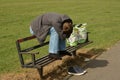 Corby, U.K., June 20, 2019 - homeless man sleeping on a bench outside