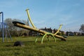 Corby, United Kingdom. April 4, 2019 - outdoor playgroung for children. Spring time, green grass. Empty swing with copy space.