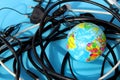 A small globe lies on a blue background surrounded by wires. Royalty Free Stock Photo