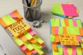 Corded phone and notebook covered with sticky notes on wooden table. April fool`s day celebration Royalty Free Stock Photo