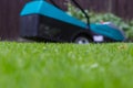 Cordless battery power lawn mower close up on green grass background Royalty Free Stock Photo