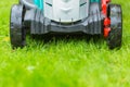 Cordless battery power lawn mower close up on green grass background Royalty Free Stock Photo