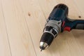 Cordless drill and screwdriver with rechargeable battery on the wooden table with copy space