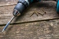 Cordless drill, wood screws on aged weathered pine wood boards