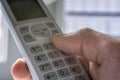 Man dials a phone number on the handset of a phone Royalty Free Stock Photo