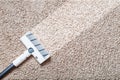 A cordless vacuum cleaner cleans the carpet in the living room with the bottom of the legs With a clean stripe Royalty Free Stock Photo