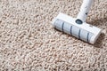 A cordless vacuum cleaner cleans the carpet in the living room with the bottom of the legs With a clean stripe Royalty Free Stock Photo