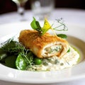 Cordon bleu with green peas and cream sauce on white plate