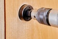 Core cutter with arbor and pilot aligned on battery drill engaged in hole cutting task on door surface viewed close from Royalty Free Stock Photo