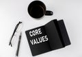CORE VALUES written text in small black notebook with coffee , pen and glasess on white background. Black-white style Royalty Free Stock Photo