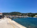 Corfu, Greece - July 7, 2018: Beautiful view of the promenade and Greek houses of Gaios town, Paxos island. Boats rest and walk