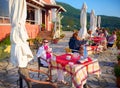 CORFU ISLAND, GREECE, JUNE 03, 2014: Young pretty woman is having dinner in classical Greek taverna restaurant cafe. Tourists and Royalty Free Stock Photo