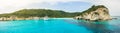 Corfu, panorama coast of Paxos island, high cliffs over the blue sea with a bay for boats