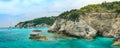Corfu, panorama coast of Paxos island, high cliffs over the blue sea with a bay for boats