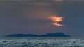 Corfu Sunset over the sea, in the background an island with an orange sun over the water