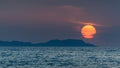 Corfu Sunset over the sea, in the background an island with an orange sun over the water