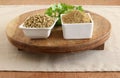 Coriander Powder with Coriander Seeds and Leaves on a Wooden Table