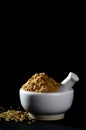 Coriander Powder and seeds with mortar and pestle on black background Royalty Free Stock Photo